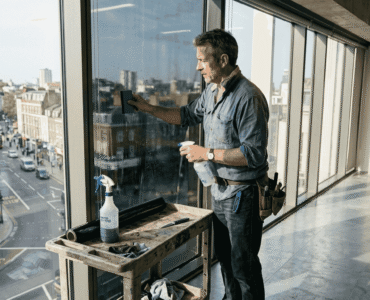 Installer applying window film in city office